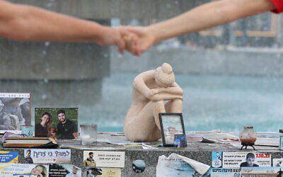 People hold hands at a memorial event marking the first anniversary of Hamas's October 7 terror onslaught, at Tel Aviv's Dizengoff Square, October 7, 2024. (Jack Guez / AFP)
