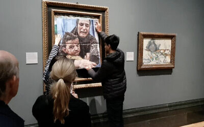 A handout picture from the Youth Demand campaign group shows an activist pasting a photo of a Gazan mother and child over Picasso's artwork entitles 'Motherhood,' at the National Gallery in central London on October 9, 2024. (AFP Photo/Youth Demand - Handout)