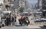 Palestinians transport their belongings as they flee areas north of Gaza City on October 12, 2024. (Omar Al-Qattaa / AFP)