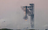Starship's Super Heavy Booster is grappled at the launch pad in Starbase near Boca Chica, Texas, on October 13, 2024, during the Starship Flight 5 test. (SERGIO FLORES / AFP)