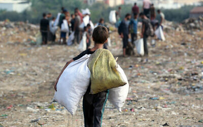 Children sift through waste at a landfill in Khan Yunis in the southern Gaza Strip on October 15, 2024. (Bashar Taleb / AFP)