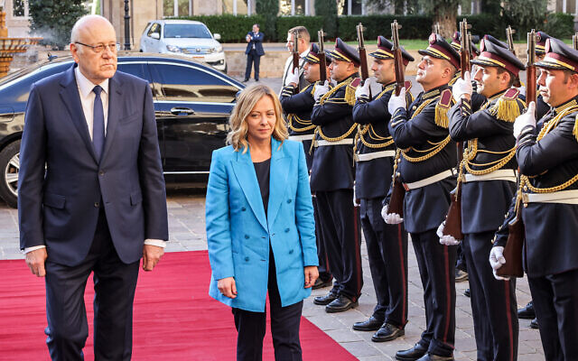 Lebanon's caretaker prime minister Najib Mikati and Italy's Prime Minister Giorgia Meloni review an honour guard during a reception for Meloni at the government palace in central Beirut on October 18, 2024. (Anwar Amro/AFP)
