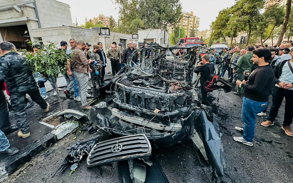 Syrian emergency and security services inspect the wreckage of a car that exploded in the Syrian Capital Damacus on October 21, 2024. (Photo by Maher AL MOUNES / AFP)