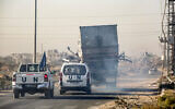 UN vehicles escort a destroyed truck reportedly used by UNRWA workers that was fired upon by Israeli forces, as it is carried by a trailer vehicle along Gaza's main Salah al-Din road outside Deir al-Balah in central Gaza on October 23, 2024. (Eyad Baba/AFP)