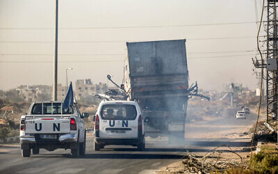 UN vehicles escort a destroyed truck reportedly used by UNRWA workers that was fired upon by Israeli forces, as it is carried by a trailer vehicle along Gaza's main Salah al-Din road outside Deir al-Balah in central Gaza on October 23, 2024. (Eyad Baba/AFP)