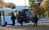 Turkish police officers gather as an armored personnel vehicle moves along a road in Kahramankazan, some 40 kilometers (25 miles) north of Ankara on October 23, 2024, near the gate of the Turkish Aerospace Industries (TAI), after a huge explosion outside the headquarters left a number of people dead and injured (Adem Altan/AFP)