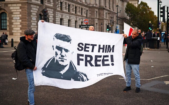 Supporters of Stephen Yaxley-Lennon, also known as Tommy Robinson carry a banner in Parliament Square after a Uniting the Kingdom march through central London on October 26, 2024. (HENRY NICHOLLS / AFP)