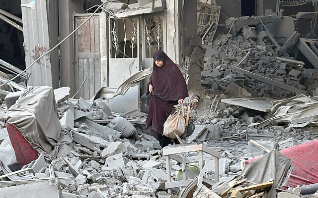 A woman walks above the rubble of a building following an Israeli strike in Beit Lahiya in the northern Gaza Strip on October 28, 2024. (AFP)