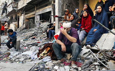 An injured man sits on the rubble of a building hit by an Israeli strike in Beit Lahiya, in northern Gaza, October 29, 2024. (AFP)