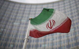 A national flag of Iran waves in front of the building of the International Atomic Energy Agency, IAEA, in Vienna, Austria, Dec. 17, 2021. (AP Photo/Michael Gruber, File)