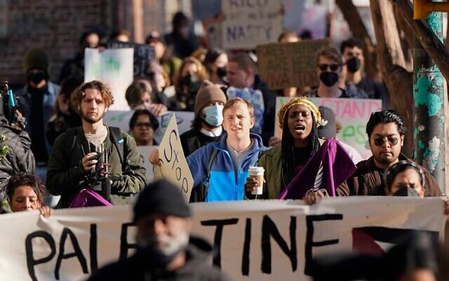 Demonstrators, also holding pro-Palestinian signs, march to the courthouse supporting 61 defendants that are being arraigned on RICO charges related to vandalism at the site of the new Public Safety Training Center, outside the a Fulton County courthouse, November 6, 2023, in Atlanta, Georgia. (AP Photo/Mike Stewart)