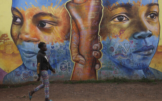Illustrative: A woman walks past an informational mural against gender-based violence, on a street in Nairobi, Kenya, March 6, 2024. (AP Photo/Brian Inganga)