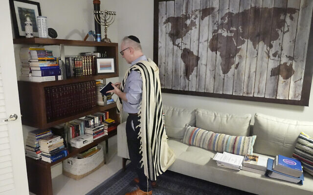 Daniel Gammerman gathers prayer items that he will use to privately worship at home during the Jewish High Holy Days, Thursday, September 26, 2024, in Miami. (AP Photo/Wilfredo Lee)