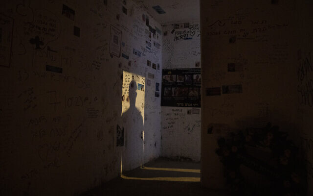 A man casts a shadow on the wall as he enters the roadside bomb shelter where Ziv Abud survived, protected by the crush of bodies above her, during the Hamas attack on October 7, 2023, near Kibbutz Reim, seen on September 26, 2024. (AP Photo/Leo Correa)