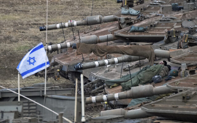 Israeli soldiers sleep on tanks in a staging area in northern Israel near the Israel-Lebanon border, October 1, 2024. (AP Photo/Baz Ratner)
