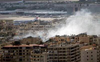 An Air China plane prepares to take off from Rafik Hariri International Airport as smoke rises from the site of an Israeli airstrike in Dahiyeh, Beirut, Lebanon, Tuesday, October 1, 2024. (AP Photo/Bilal Hussein)