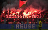 Celtic fans waving a Palestinian flag hold smoke flares during the Champions League opening phase soccer match between Borussia Dortmund and Celtic FC at the BVB Stadion in Dortmund, Germany, Tuesday, Oct. 1, 2024. (AP Photo/Martin Meissner)