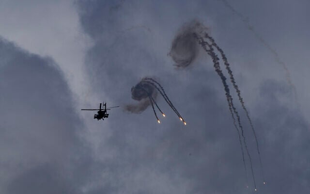 An Israeli Apache helicopter releases flares near the Israeli-Lebanon border, as seen from northern Israel, October 2, 2024. (AP/Baz Ratner)