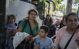 Greek citizens, who were evacuated from Lebanon with a Greek military transport aircraft stand outside the Greek Foreign ministry building in central Athens, on Thursday, Oct. 3, 2024. (AP Photo/Petros Giannakouris)