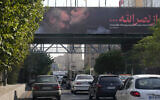 Vehicles drive past a billboard showing the late Iranian Revolutionary Guard Gen. Qassem Soleimani, who was killed in Iraq in a US drone attack in 2020, kissing forehead of slain Hezbollah leader Hassan Nasrallah, in Tehran, Iran, October 5, 2024. (AP Photo/ Vahid Salemi)
