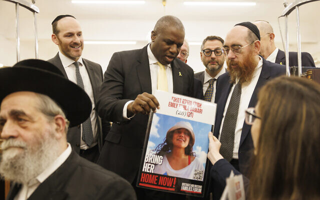 Members of the Jewish community stand with the Britain's Foreign Secretary David Lammy, center, at South Tottenham United Synagogue in London Monday, Oct. 7, 2024, on the one-year anniversary of the Oct. 7 Hamas attacks in Israel. (Dan Kitwood/Pool Photo via AP)