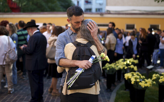 Rotem gets a hug from her husband Yoav after a commemoration marking one year since the Hamas terror attacks on Israel, held at the Coral Temple Synagogue, in Bucharest, Romania, October 7, 2024. (Vadim Ghirda/AP) Rotem gets a hug from her husband Yoav after a commemoration marking one year since the Hamas terror attacks on Israel, held at the Coral Temple Synagogue, in Bucharest, Romania, October 7, 2024. (Vadim Ghirda/AP)