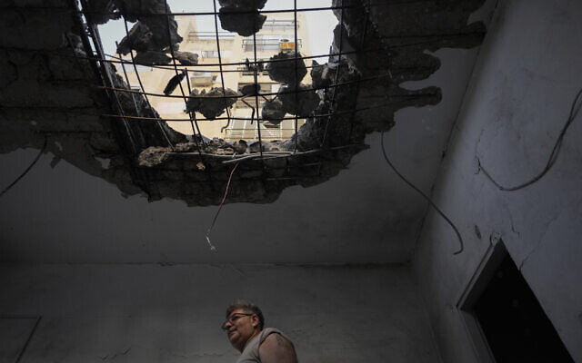 A man examines his damaged apartment that was hit by a Hezbollah rocket fired from Lebanon in Kiryat Yam, northern Israel, on Tuesday, Oct. 8, 2024. (AP Photo/Ariel Schalit)