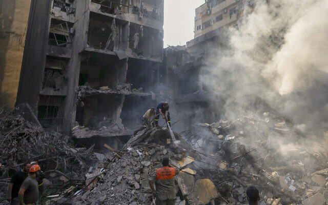 Rescue workers search at the site of Thursday's Israeli airstrike in Beirut, Lebanon, Friday, Oct. 11, 2024. (AP Photo/Hassan Ammar)