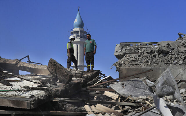 A Hezbollah rescue worker, left, and a Lebanese civil defense worker, right, stand on the rubble of destroyed buildings at a commercial street that was hit Saturday night by Israeli airstrikes, in Nabatiyeh town, south Lebanon, Sunday, Oct. 13, 2024. (AP Photo/Mohammed Zaatari) A Hezbollah rescue worker, left, and a Lebanese civil defense worker, right, stand on the rubble of destroyed buildings at a commercial street that was hit Saturday night by Israeli airstrikes, in Nabatiyeh town, south Lebanon, Sunday, Oct. 13, 2024. (AP Photo/Mohammed Zaatari)
