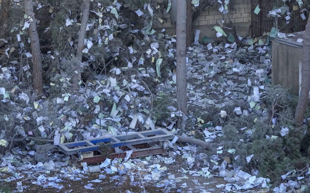 Documents of Hezbollah-linked Al-Qard Al-Hassan financial association are scattered at the site of an Israeli airstrike in Beirut's southern suburb, Lebanon, Oct. 21, 2024. (AP/Hassan Ammar)