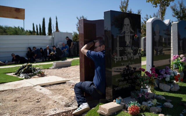 People take cover as a siren warns of incoming rockets during the funeral of Alexei Popov, who was killed during a rocket attack fired from Lebanon last weekend, at the Tel Regev cemetery in the outskirts of Haifa, northern Israel, Monday, Oct. 21, 2024. (AP Photo/Leo Correa) People take cover as a siren warns of incoming rockets during the funeral of Alexei Popov, who was killed during a rocket attack fired from Lebanon last weekend, at the Tel Regev cemetery in the outskirts of Haifa, northern Israel, Monday, Oct. 21, 2024. (AP Photo/Leo Correa)