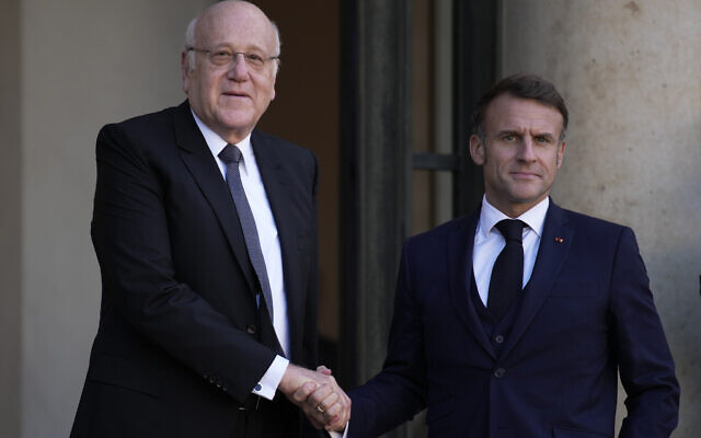 French President Emmanuel Macron welcomes Lebanese caretaker Prime Minister Najib Mikati, left, Wednesday, Oct. 23, 2024 at the Elysee Palace in Paris. (AP Photo/Louise Delmotte)