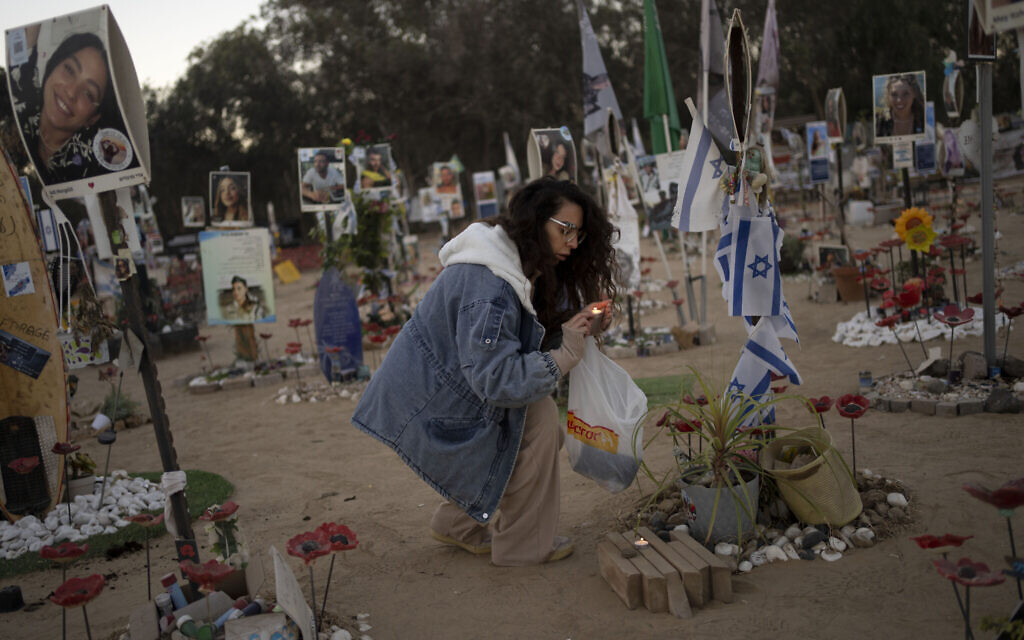 A woman lights candles at the site of the Nova music festival, where hundreds of revelers were killed or kidnapped by Hamas, on the Jewish holiday of Simchat Torah, marking one year in the Hebrew calendar since the attack, near Kibbutz Re'im, southern Israel, October 24, 2024. (AP Photo/Maya Alleruzzo)
