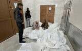 Palestinians gather in a morgue with bodies said to be of relatives allegedly killed in Israeli airstrikes in the city of Khan Younis, southern Gaza Strip, October 25, 2024. (AP Photo)