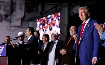 Republican presidential nominee former US president Donald Trump, right, looks on as local Muslim leaders speak during a campaign rally at the Suburban Collection Showplace, October 26, 2024, in Novi, Michigan. (AP Photo/Alex Brandon)