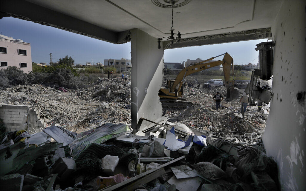 Rescue workers use an excavator to clear the rubble of a destroyed building hit in an Israeli airstrike, as they search for victims, in Sarafand, southern Lebanon, October 30, 2024. (AP Photo/Bilal Hussein)