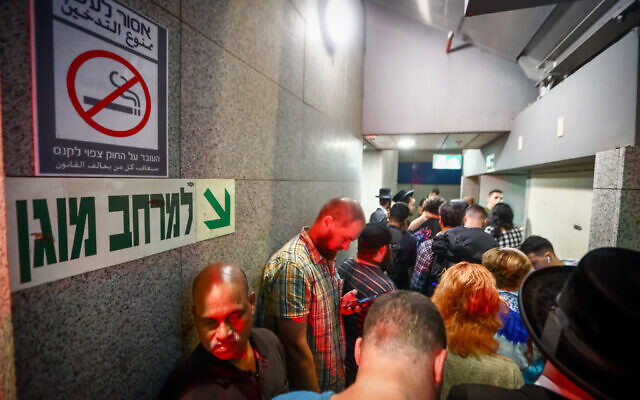 Israelis take cover inside a bomb shelter at Ben Gurion Airport as a siren alert is sounds amid an Iranian missile attack October 1, 2024. (Dor Pazuelo/Flash90) Israelis take cover inside a bomb shelter at Ben Gurion Airport as a siren alert is sounds amid an Iranian missile attack October 1, 2024. (Dor Pazuelo/Flash90)