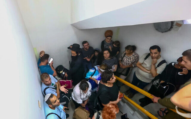 Israelis take cover inside a bomb shelter at Ben Gurion Airport amid a mass Iranian missile attack, October 1, 2024. (Dor Pazuelo/Flash90) Israelis take cover inside a bomb shelter at Ben Gurion Airport amid a mass Iranian missile attack, October 1, 2024. (Dor Pazuelo/Flash90)