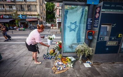 People lay flowers at the site of a deadly terror shooting attack the night before in Jaffa, October 2, 2024. (Dor Pazuelo/Flash90)