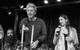 In this undated photo, Phil Lesh, center, lights candles as Jeannette Ferber, right, a cantorial soloist at Berkeley's Renewal congregation Chochmat HaLev, sings a blessing and guitarist Ross James looks on. (© Bob Minkin Photography / www.minkinphotography.com)