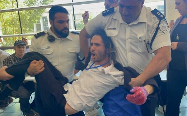 An anti-government protester is removed from the Knesset by security guards on October 28, 2024 (Sam Sokol/Times of Israel) An anti-government protester is removed from the Knesset by security guards on October 28, 2024 (Sam Sokol/Times of Israel)