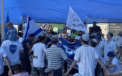 Settler activists dance at a conference calling for the establishment of Jewish settlements in Gaza, close to the Israel-Gaza border, October 21, 2024. (Jeremy Sharon/Times of Israel)