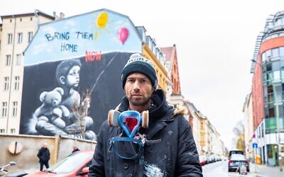 Graffiti artist Benzi Brofman painting one of his murals about the October 7, 2023, Hamas onslaught, this one in Germany, in an undated photo. (Courtesy Ruthe Zuntz)