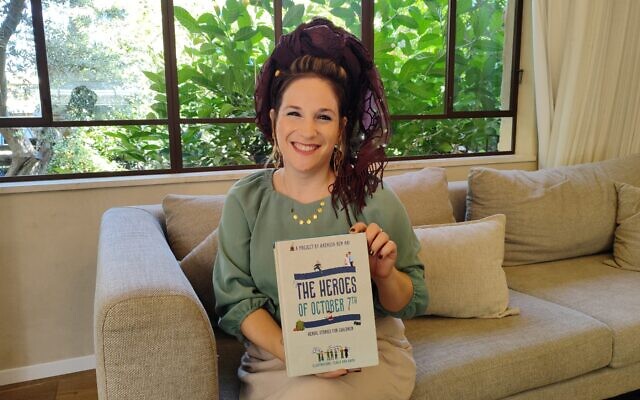 Hadassah Ben-Ari at her home in Pardes Hannah with a copy of her book, 'The Heroes of October 7,' on September 30, 2024. (Gavriel Fiske/Times of Israel)
