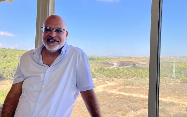 Ahmed Samniya stands by his porch window in Sheikh Danun, Western Galilee, on October 8, 2024. (Diana Bletter/Times of Israel)