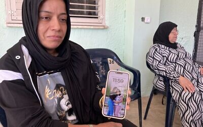 Areej Manaa holds her phone with a photo of her daughter, Orjwan, killed by a Hezbollah rocket in Majd al-Krum on October 25, 2024, at her home on October 29, 2024. (Diana Bletter/Times of Israel)