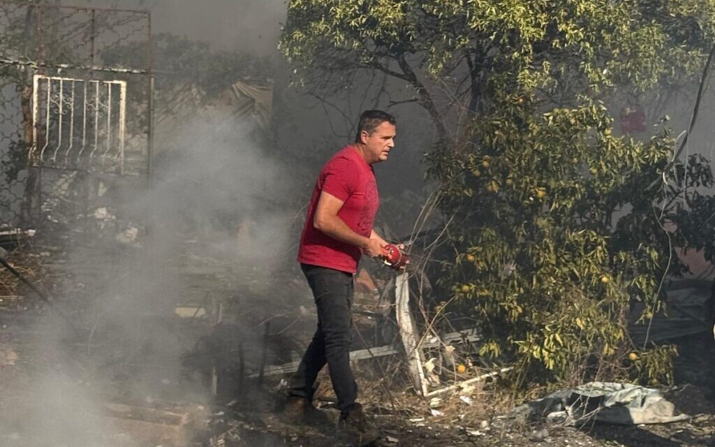 Neighbors attempt to douse fires after a rocket attack on a house in Netiv Hashayara on October 24, 2024. (Margalit Boyarsky) Neighbors attempt to douse fires after a rocket attack on a house in Netiv Hashayara on October 24, 2024. (Margalit Boyarsky)