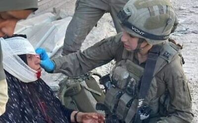 Cpl. Shai Gilboa, a paramedic in the IDF's 9th Battalion, treats a Gaza woman with an injury on her lower face that she said was the result of Hamas's attempts to prevent civilians from fleeing Jabaliya in northern Gaza to designated safe zones, October 21, 2024. (Via social media, used in accordance with clause 27a of the copyright law)