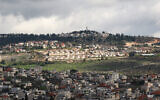 File: A picture taken in the village of Turmus Ayya near Ramallah shows the nearby Israeli Shiloh settlement in the background, in the West Bank on February 18, 2024. (Jaafar ASHTIYEH / AFP)
