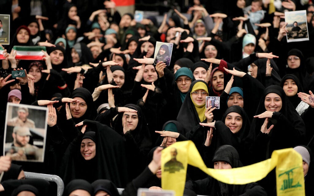 A handout picture provided by the office of Iran's Supreme Leader Ayatollah Ali Khamenei on November 2, 2024, shows students making a gesture seen as a threat to American troops during a meeting with him in Tehran. (Khamenei.ir/AFP)